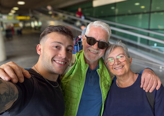 Obraz premium Young Man Taking Selfie With Smiling Senior Couple At Airport Terminal While Traveling Together