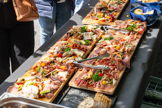 Buffet traiteur avec planches de charcuterie, fromages et tapas lors d&rsquo;un &eacute;v&eacute;nement convivial en ext&eacute;rieur.