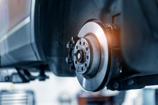 Closeup of steel brake disc in car service. Concept for replacing wheel pads in garage.