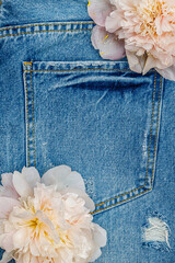 Flowers placed on denim fabric with a pocket in view during daylight © Fleuronica