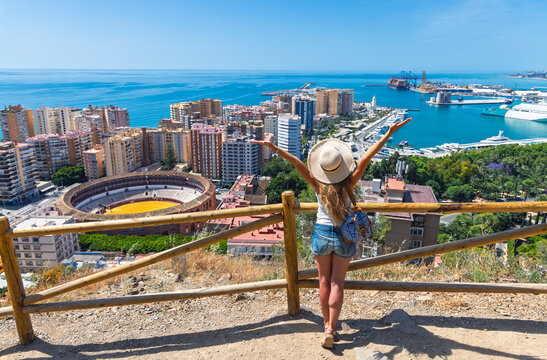 Cheerful traveler woman looking at malaga cityscape with la malagueta bullring from gibralfaro viewpoint. Travel destination, tour tourism in Spain, Andalusia