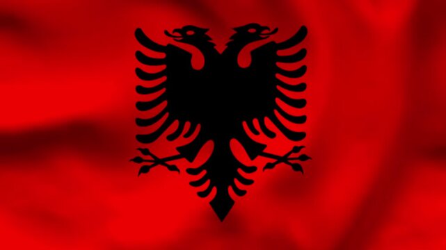 National flag of Albania with the black double-headed eagle on a red wavy fabric background. Professional top-down shot of textile ripples for national celebrations, holidays, and news media.