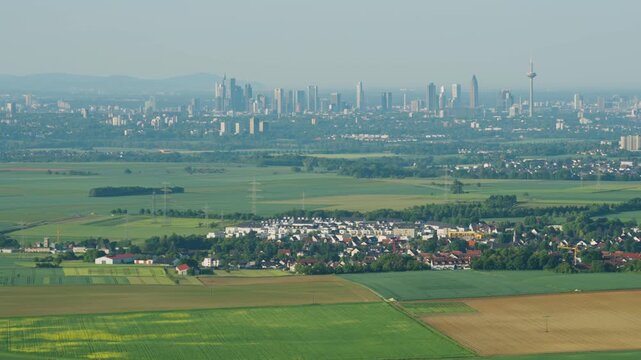 Aerial view of a field at sunrise. A landscape from a drone perspective, with a view of the metropolis of Frankfurt am Main. An agricultural landscape from the air.
