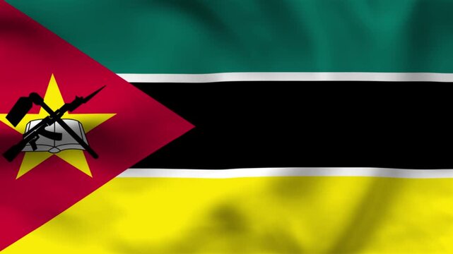 National flag of Mozambique on wavy cloth. Features horizontal stripes and a red triangle with a star, rifle, and book emblem. Top-down view for national news and independence celebrations.
