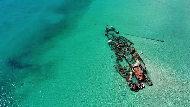 Aerial view of the rusted Shipwreck Epanomi resting in crystal clear turquoise waters near the sandy beach Epanomi, Greece.