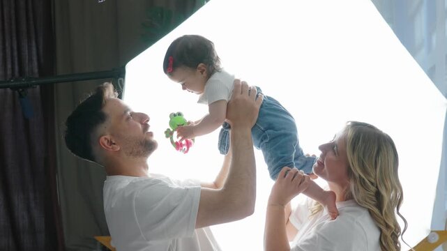 A cheerful family with a happy, baby. The parents are smiling and looking lovingly at their daughter. "Focus on the Family" Video Concept
