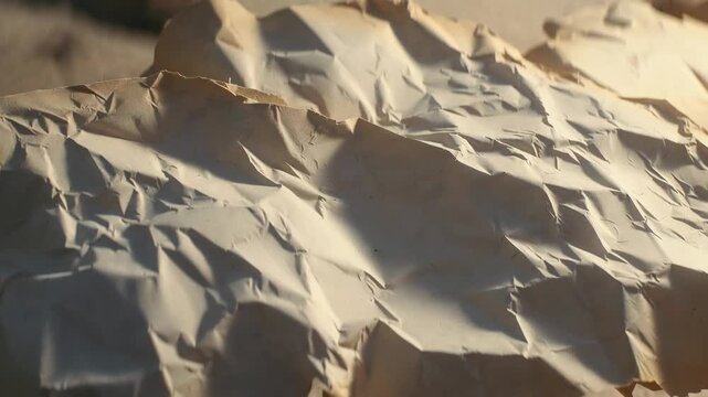Crumpled beige paper sheet in soft photographic style on a neutral background, symbolizing texture and imperfection