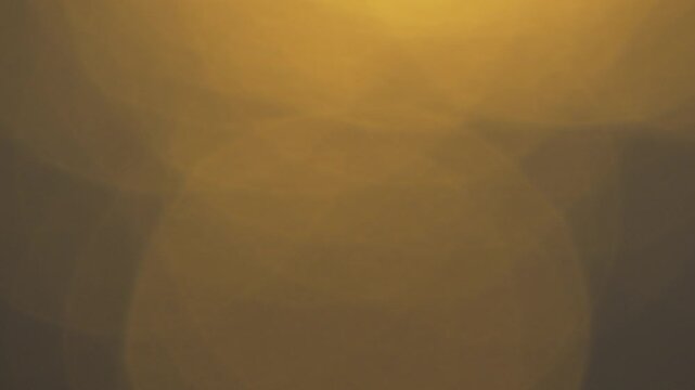 Bokeh light abstract soft golden shimmering orbs dancing in a warm amber background for a dreamy and elegant atmosphere