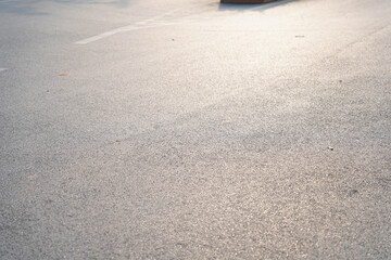 Sundrenched asphalt street with warm sunlight hitting the pavement in urban public space © Sopear