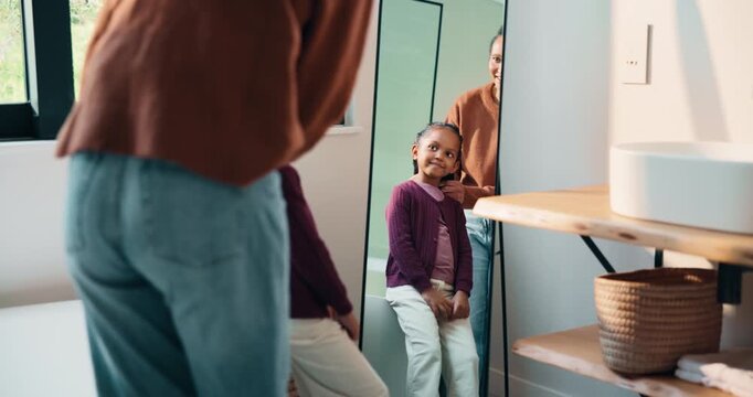 Mirror, hair care and mother with child in bathroom, grooming routine and support for wellness. Morning hug, reflection and happy woman with girl for getting ready, hairstyle and high five in home