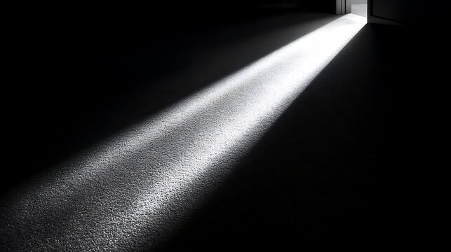 Bright beam of light streaming through open doorway into dark room creating high contrast shadows on floor representing hope opportunity and new beginnings in life