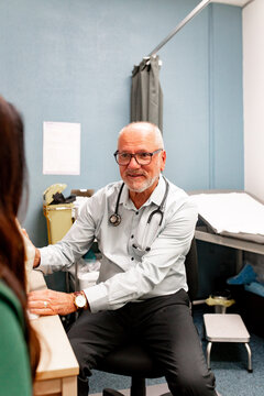 Doctor consulting patient in examination room with medical equipment