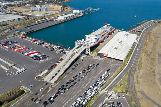 Aerial view of cars boarding a passenger ferry at a shipping terminal
