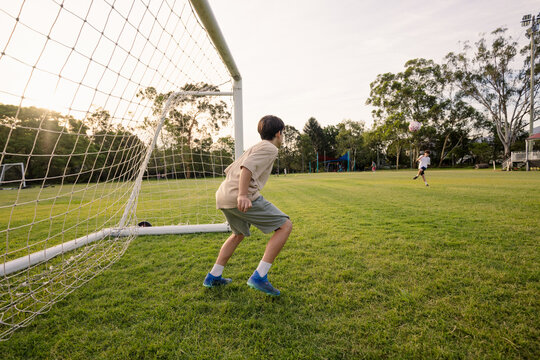 Young soccer player on defensive stance in front of soccer goal