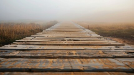 Fototapeta premium A wooden boardwalk extends into the haze, with a pilgrim walking on the camino path