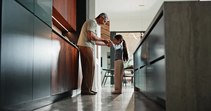 Father, girl and dancing in kitchen with holding hands, bonding and connection in morning at house. Happy people, dad and child with rhythm, love and spin for relationship with care in family home