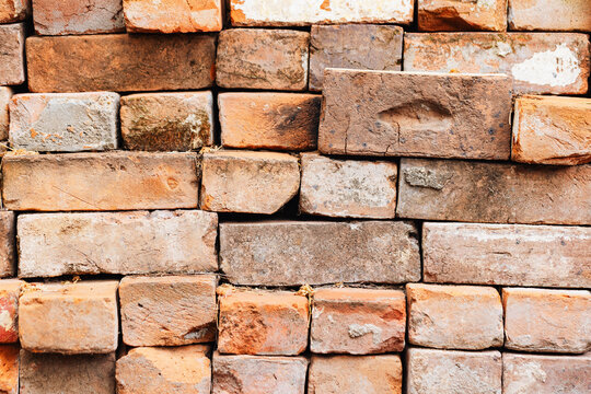 Weathered and aged brick stack texture with visible imperfections and natural colour variations