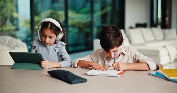 Children, home and tablet with books for elearning, education or childhood development together. Kids, siblings or interaction with technology, writing or notebook for studying or knowledge in house
