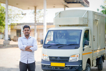 young indian man standing with transport vehicle