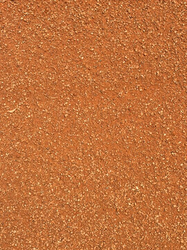 Red baseball infield dirt texture background filled with crushed clay