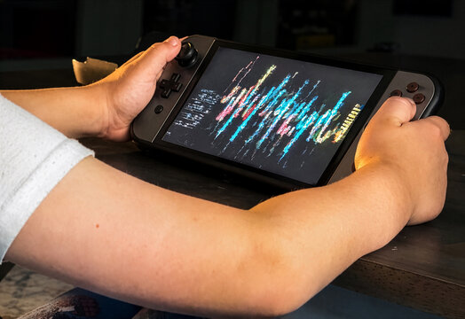 Child holding a generic video game console and playing games