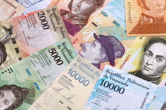 Venezuelan bolivar money bills pile on table. Venezuela banknotes of VES currency close up.