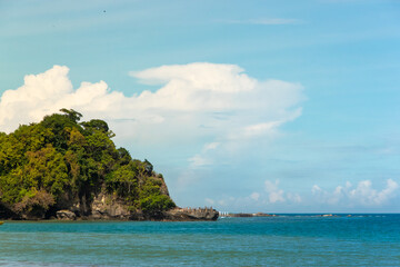 Obraz premium Waves Crashing on Tropical Island Coastline at Sunrise Over Calm Blue Ocean and Sandy Beach