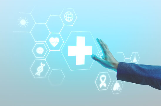Hand reaching toward glowing medical cross with healthcare icons