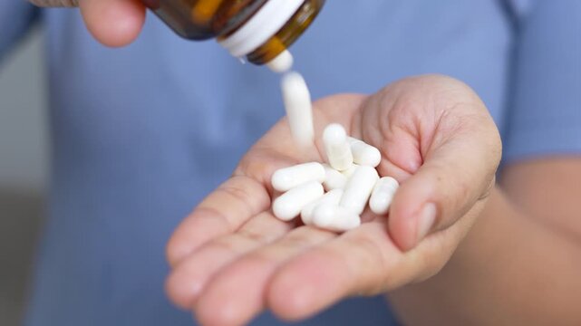 woman is holding headache pills to reduce her fever.