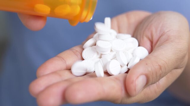 woman is holding headache pills to reduce her fever.