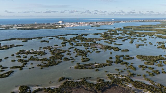 Aerial view of Yucalpeten lagoon with numerous mangrove islands and the city skyline in the distance under a clear sky Progreso, Yucatan, Mexico.