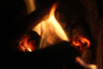 Fototapeta premium Cozy Wood Fire Burning in a Dark Rustic Fireplace Close Up