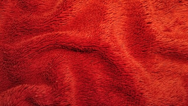 ​Red fuzzy fleece fabric texture background with soft folds
