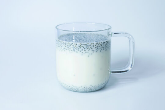 Chia seeds in soy milk in a clear glass isolated on white background.