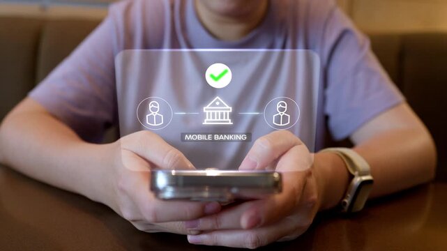 Close up of a person using a smartphone for mobile banking and online money transfer, displaying a futuristic fintech hologram interface in a cashless society concept.