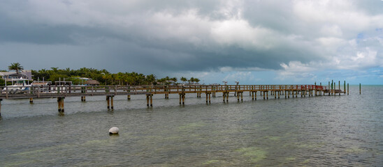 Fototapeta premium Pier promenade deck at the sea view. Seafront promenade by pathway at beach. Pier path on promenade beach with nobody. Sea horizon