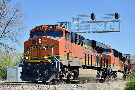 Multiple locomotives direct a Burlington Northern Santa Fe stack train through a curve, and under a signal bridge contolling access to a crossing with another railroad, in north cental Illinois.