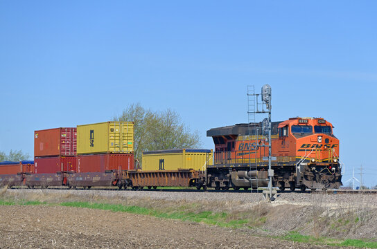 A single locomotive leads a Burlington Northern Santa Fe stack train past a signal along a rural stretch of right-of-way as it rolls eastbound through north central Illinois. 