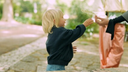 Obraz premium Toddler offers pink bag while showing warm trust and affection