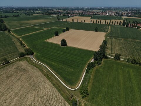 Agricultural Landscape Aerial View: An expansive aerial perspective reveals a patchwork of cultivated fields, some green and vibrant, others fallow, San Martino Olearo, Milan, Italy
