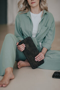 Woman practicing meditation with sadhu boards indoors, mindfulness and spiritual wellness ritual, calm self-development practice with nail standing boards in minimalist interior