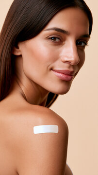 A beautiful woman with a white medical nicotine or contraceptive patch on her upper arm.