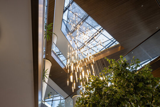 Stunning low angle view of massive modern chandelier and skylight glass roof