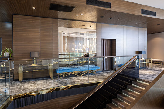 Luxury modern interior with glass staircase railing and stylish blue benches