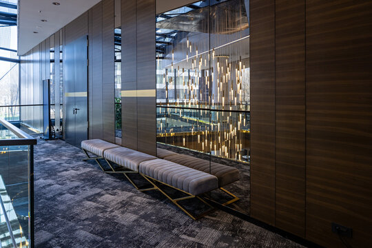 Elegant hotel corridor with upholstered benches and decorative lighting reflection