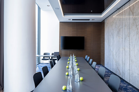 Contemporary conference room with long table and modern digital screen