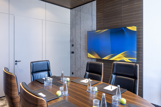 Luxury boardroom interior with round wooden table and executive chairs
