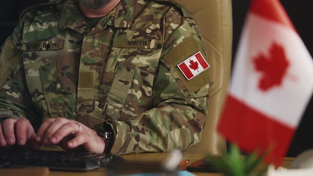 Canadian army officer working on computer in military hub, planning mission