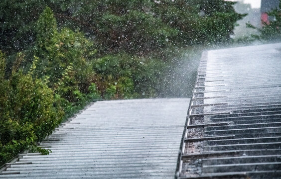 Starkregen prasselt auf ein Wellblechdach