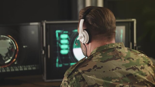 Middle-aged military officer in headset analyzing radar data for security threat